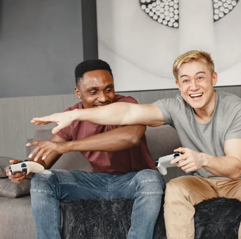 Two friends laughing while playing a game together